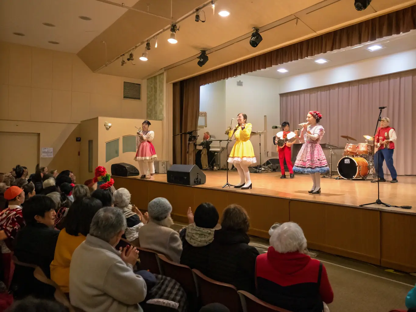 A vibrant image of participants engaged in a dance workshop, showcasing movement and joy, set in a community hall with wooden floors and large windows.